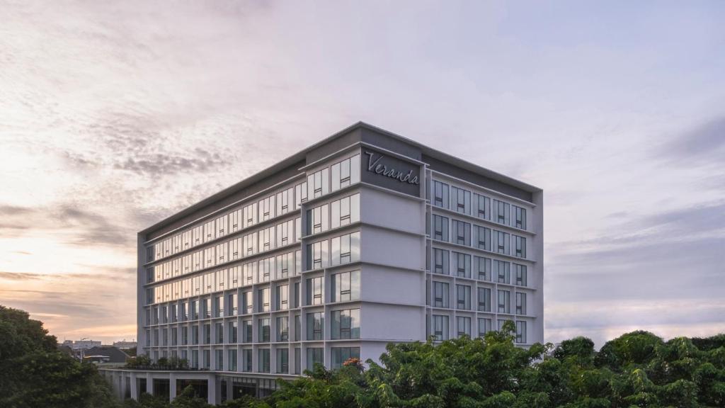 um edifício branco alto com muitas janelas em Veranda Hotel Pakubuwono em Jakarta