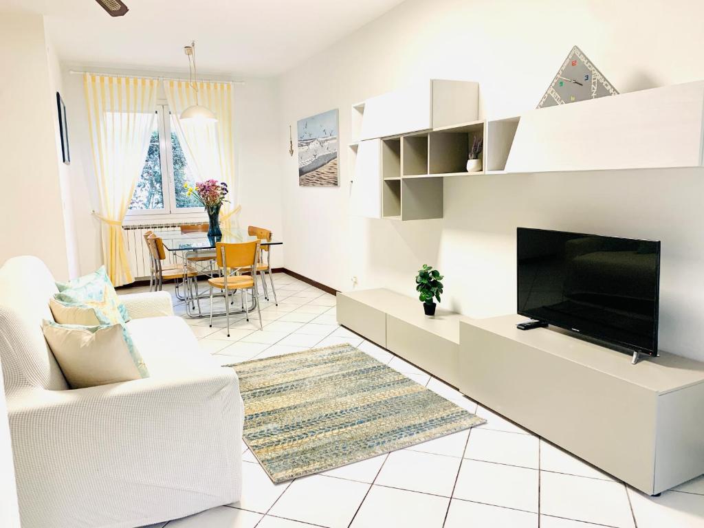 un soggiorno con TV a schermo piatto e mobili bianchi di Villa Azzuro Blue a Lignano Sabbiadoro