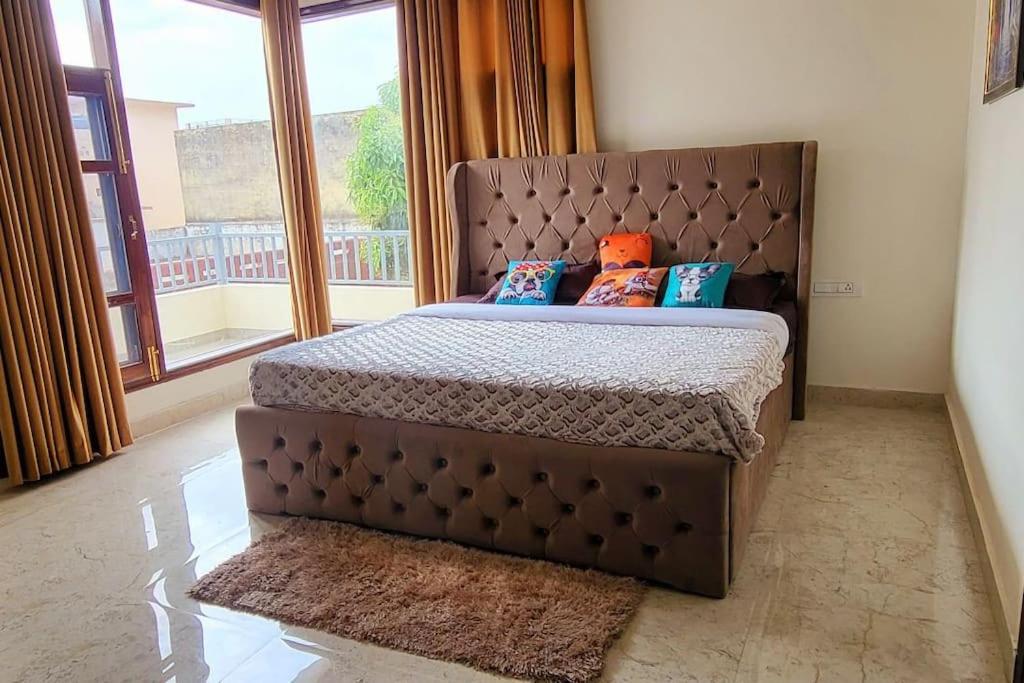 a large bed in a room with a large window at Luxury Villa with Free Breakfast - RnR Manor in Kālka