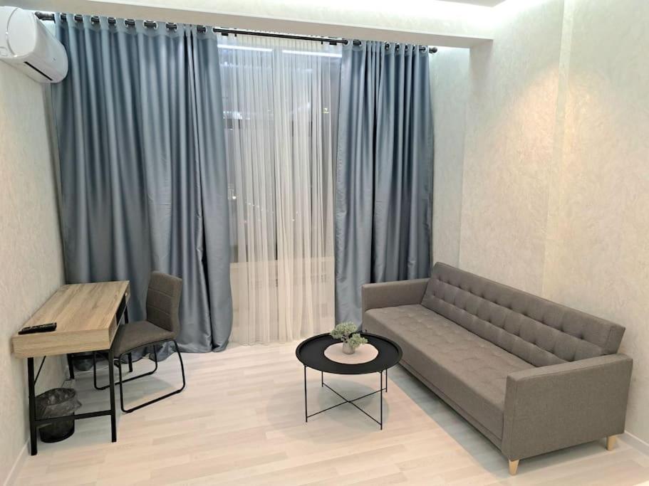 a living room with a couch and a table at Apartment in City Center in Dushanbe