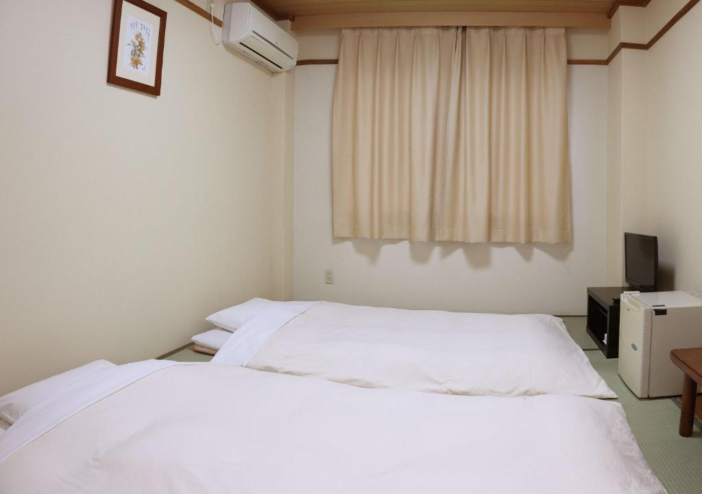 Postel nebo postele na pokoji v ubytování Business Hotel Isesaki Heisei Inn