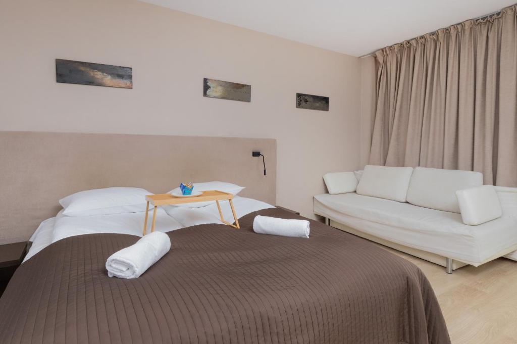a hotel room with two beds and a couch at Seaside Studio with Balcony by Renters in Władysławowo