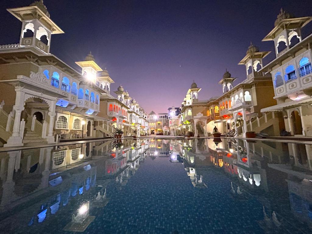 a courtyard of a building with a pool of water at night at Hotel Gautam Lonavala in Lonavala