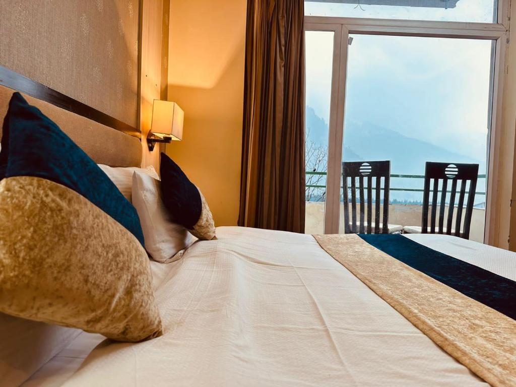 a bedroom with a bed with a view of the ocean at The Royal Majestic Mountain View in Manāli
