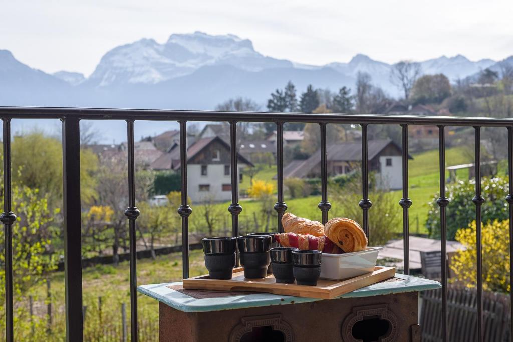 une assiette de nourriture sur une table sur un balcon dans l'établissement ST JORIOZ- Le Nid O Grives, maison familiale entre lac et montagnes- Home cinema- LLA Selections by Location lac Annecy, à Saint-Jorioz