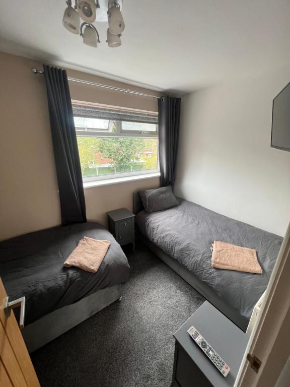 a small bedroom with two beds and a window at 2 bed semi-detached house in Warrington