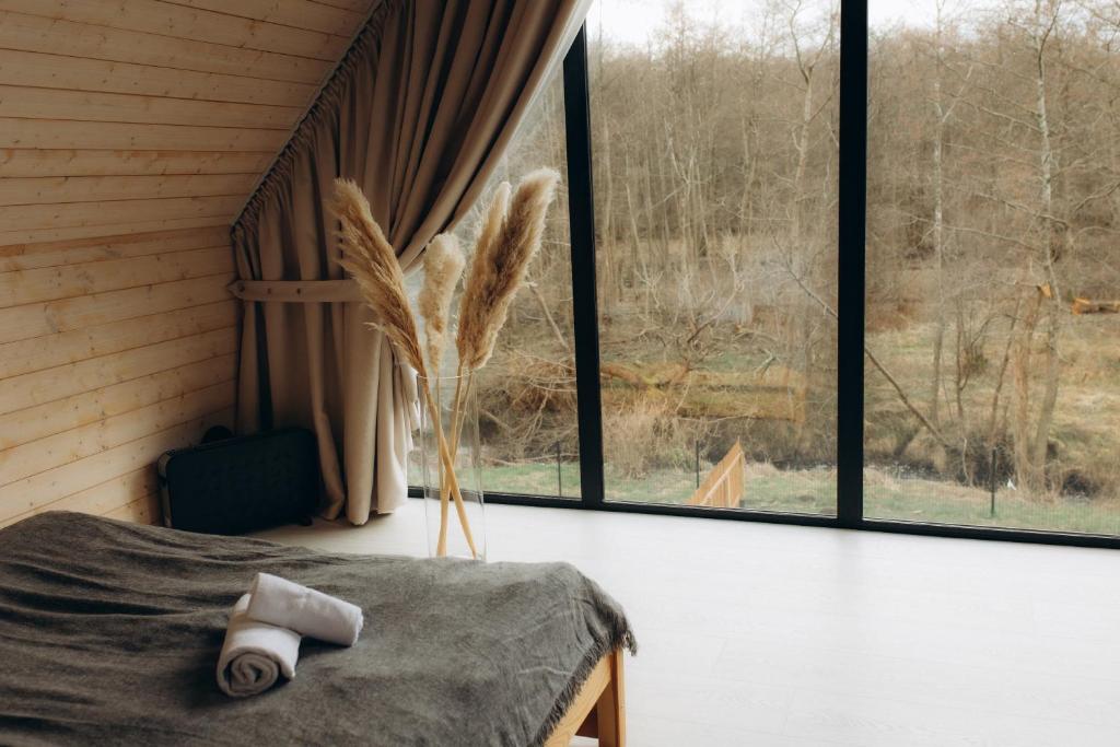 een kamer met een bed en een groot raam bij Domki Momenty in Słajszewo