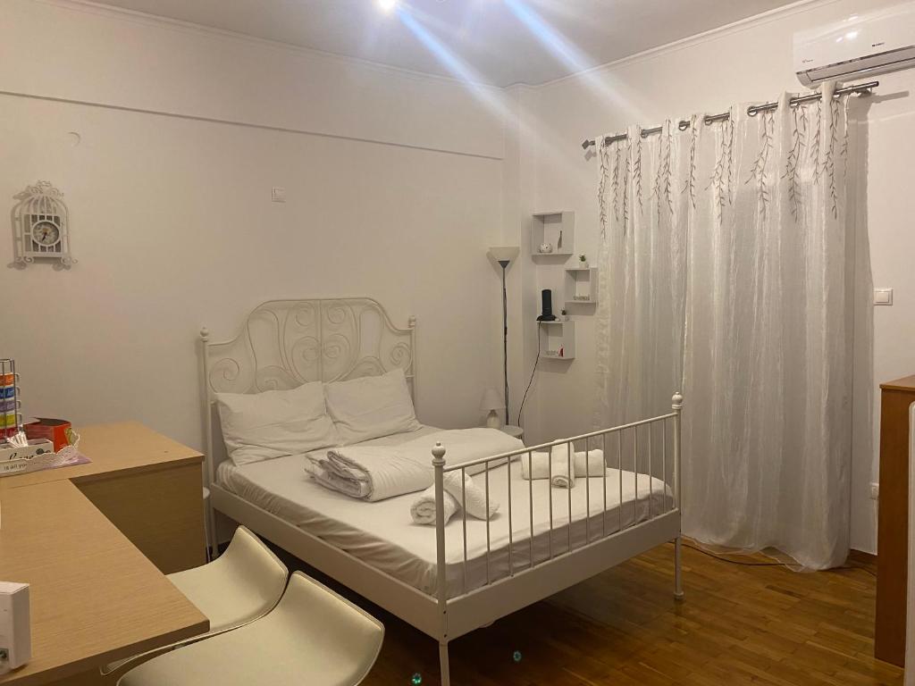 a small bedroom with a crib and a desk at Modern, ideally located studio apartment in Athens