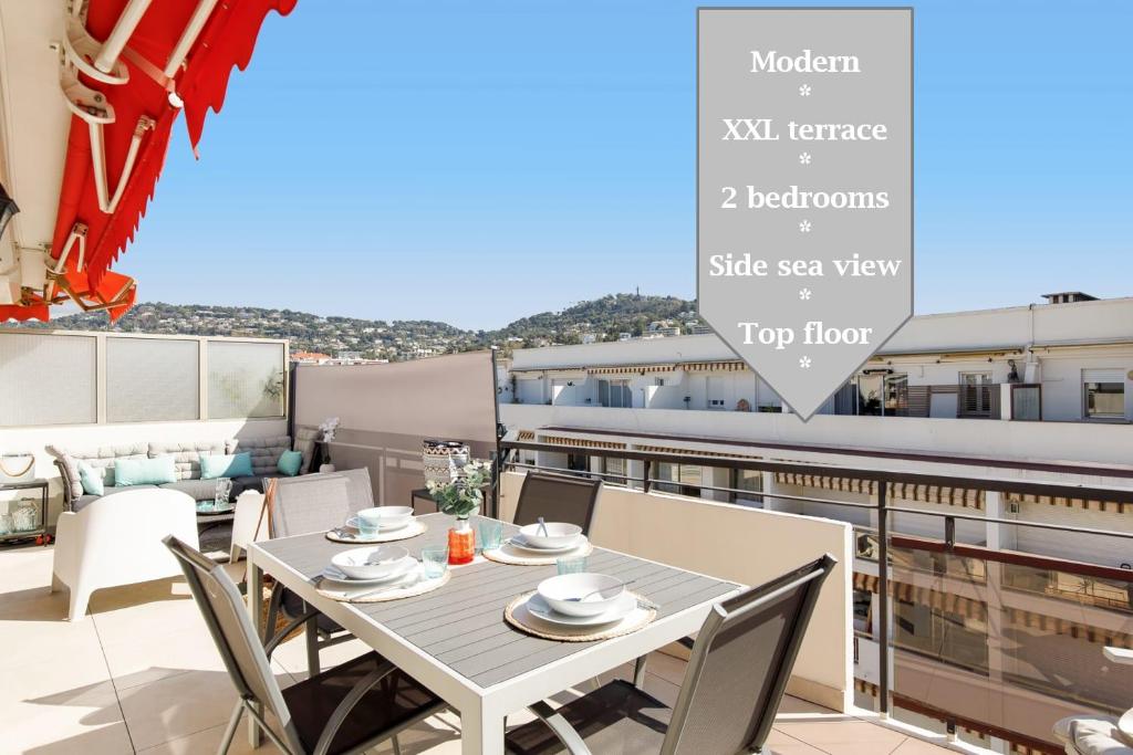 einen Balkon mit einem Tisch und Stühlen auf dem Dach in der Unterkunft XXL 2 beds with XXL terrace next to Martinez Hotel in Cannes