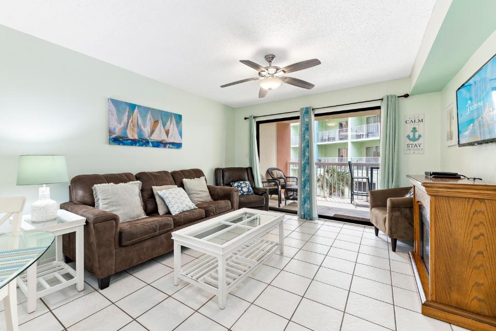 ein Wohnzimmer mit Sofa und Tisch in der Unterkunft Harbor Place 206 in Gulf Shores