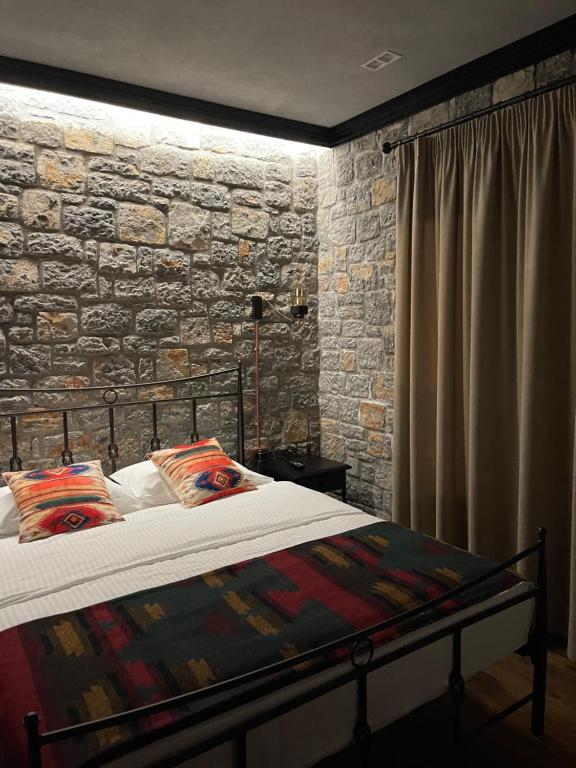 een slaapkamer met een bed en een stenen muur bij Helga's Guesthouse in Lin