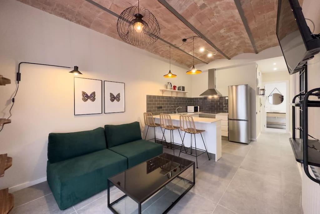 sala de estar con sofá verde y cocina en New 2 bedroom apartment in Plaza España, en Barcelona