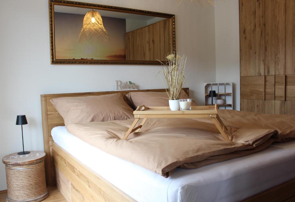 Una cama con una mesa de madera encima. en Apartment Blicksüd, en Unterburg am Klopeiner See