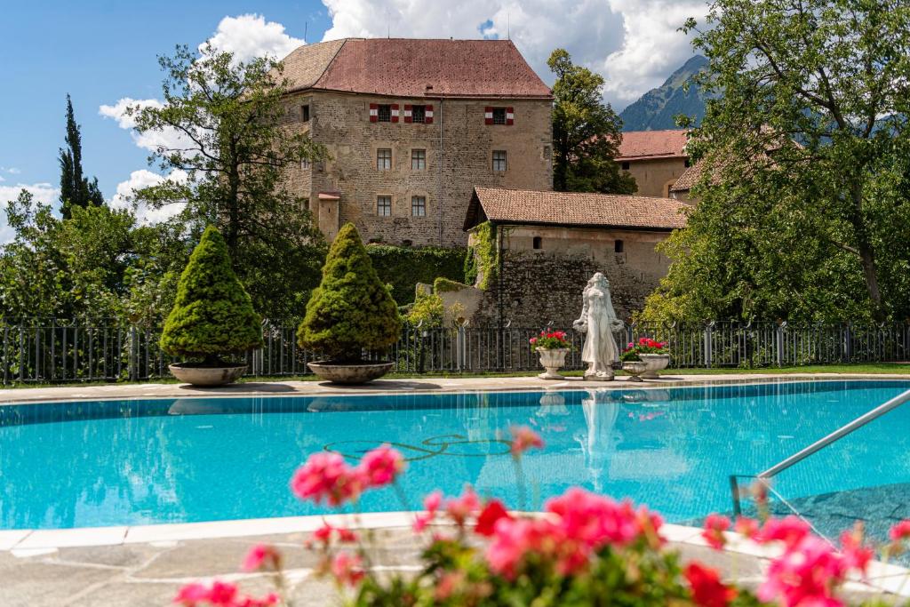 a swimming pool in front of a large building at Hotel Starkenberg in Schenna