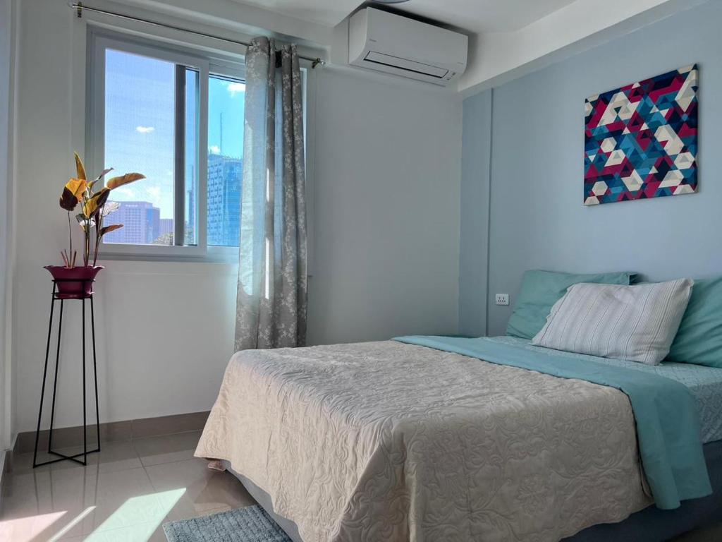 a bedroom with a bed and a large window at Cebu Mini Hotel in Cebu City