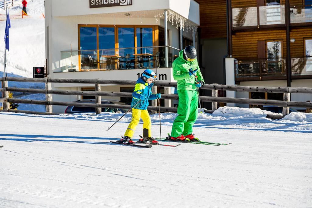 a man and a child on skis in the snow at Sissi Park in Lachtal