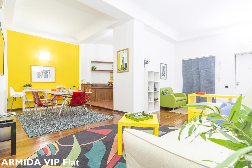 un soggiorno con pareti gialle, tavolo e sedie di da ARMIDA VIP Flat a Napoli