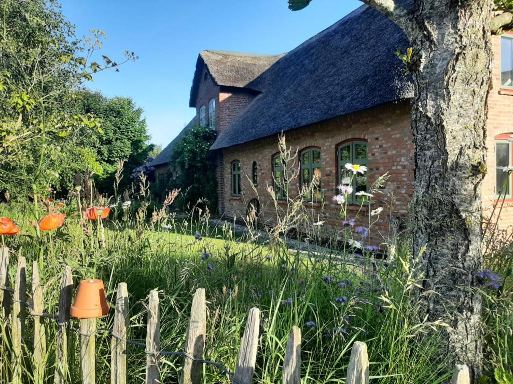 an old house with a fence in front of it at NEU Feriendomizil Nordfriesland Pur in Braderup