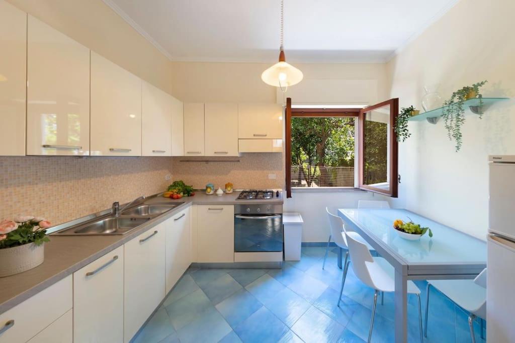 eine Küche mit weißen Schränken und blauem Boden in der Unterkunft Maison Marianna in Sorrent