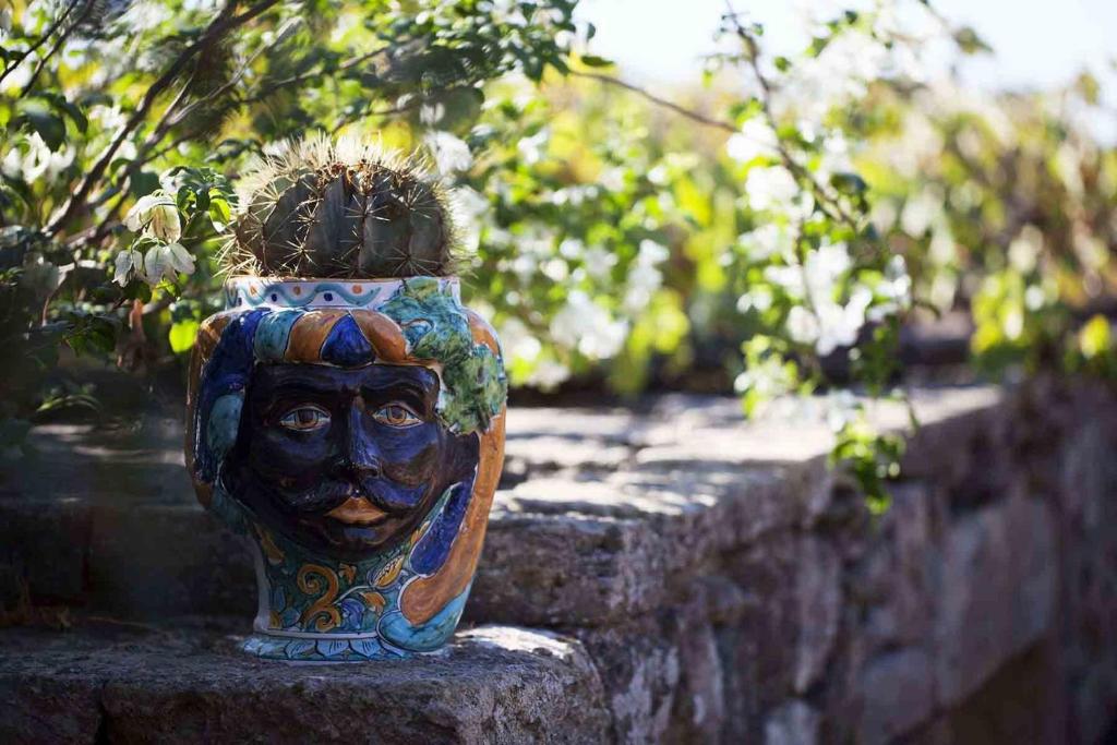 a vase with a face on it sitting on a wall at Tenuta Borgia in Pantelleria