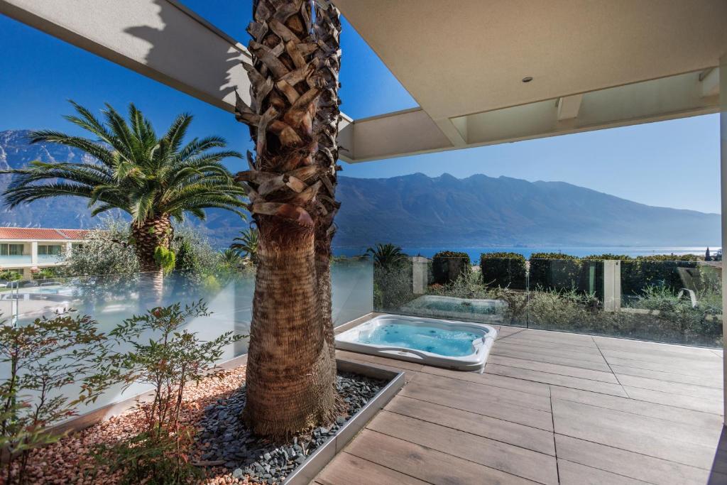 a house with a palm tree and a swimming pool at Park Hotel Imperial in Limone sul Garda