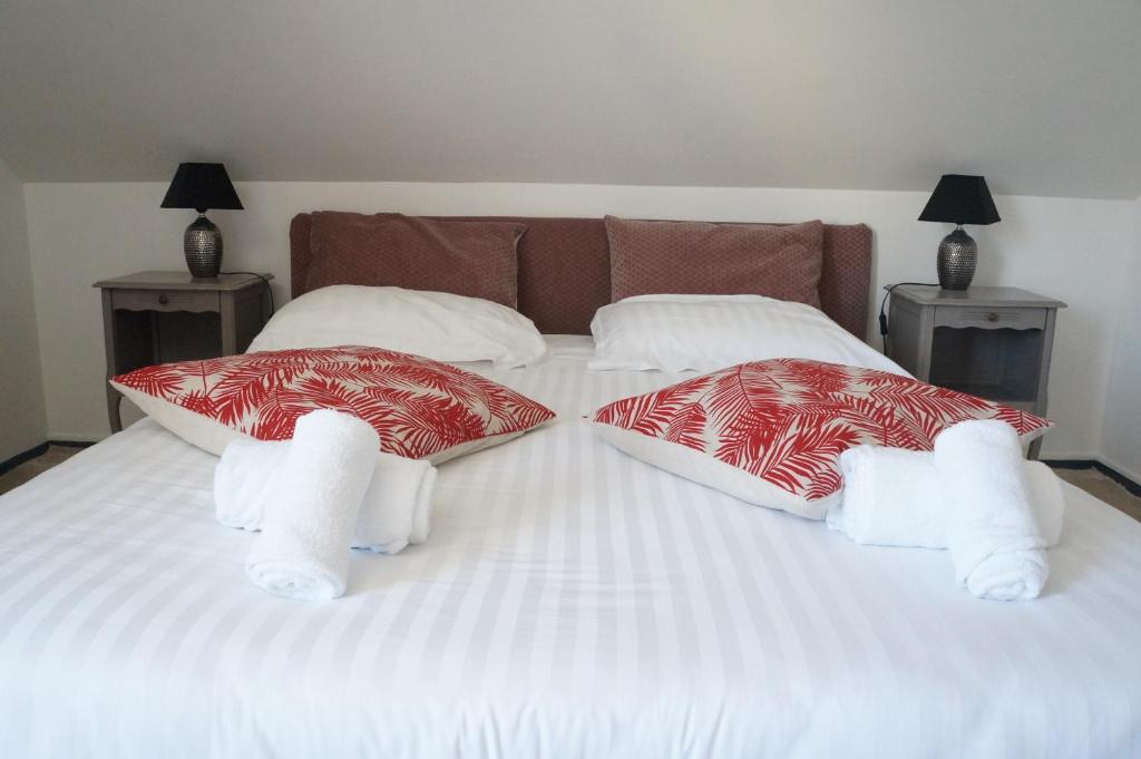 a white bed with two pillows on it at Hotel et Studios Le Marina Baie de La Baule in Pornichet