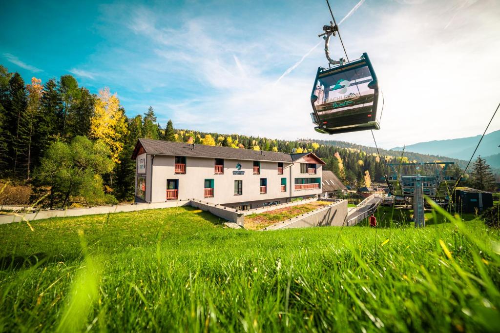 a gondola ride in the sky over a building at Apartmány Bachledka in Ždiar