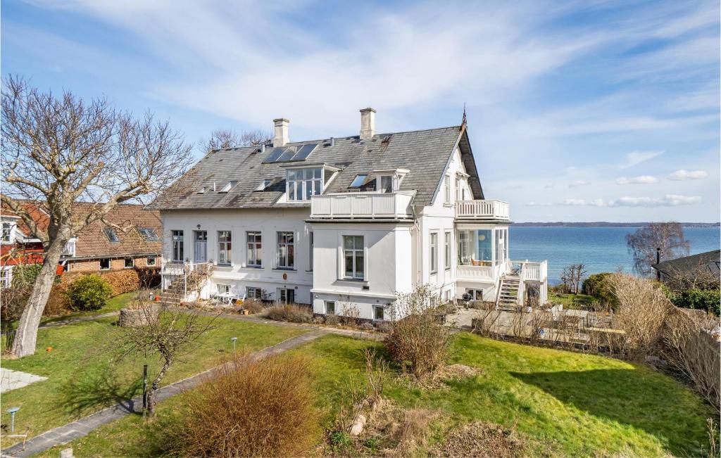 a large white house with a view of the water at Beautiful Home In Hellebk With House Sea View in Hellebæk