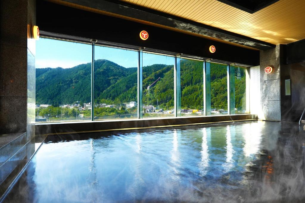 a swimming pool with a view of a mountain at Ooedo Onsen Monogatari Kounkaku in Osaki
