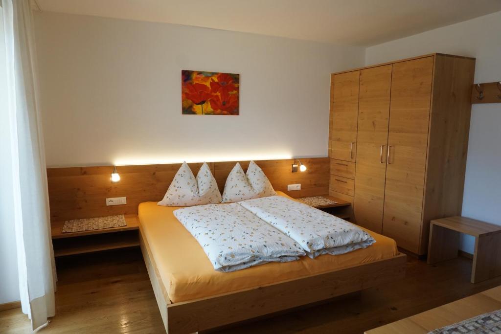 sypialnia z dużym łóżkiem i szafką w obiekcie Waalhof Ferienwohnung Mohnblume w mieście Silandro
