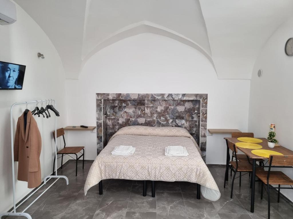 a bedroom with a bed and a table and chairs at SUITE AGATA in Gallipoli