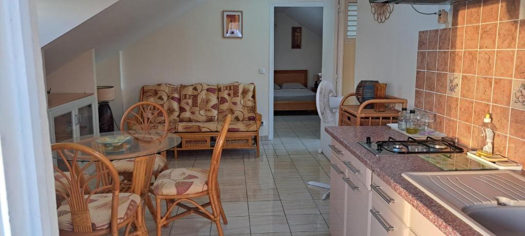 cocina y sala de estar con mesa y sillas en Logement spacieux deux pièces à Baie Mahault, en Baie-Mahault