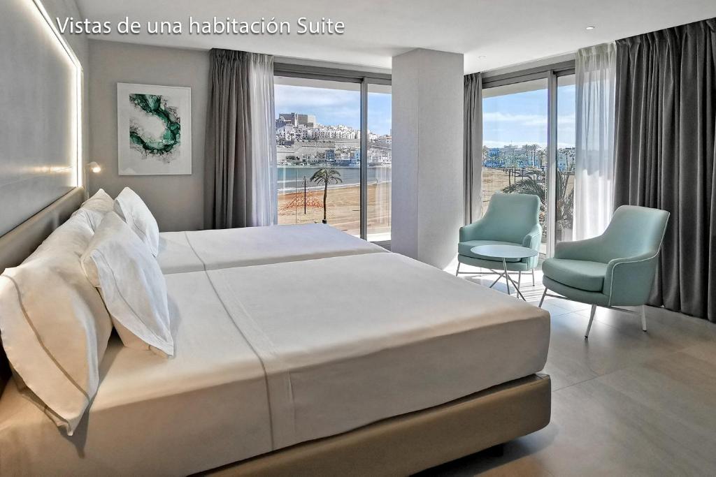 1 dormitorio con 1 cama grande y 2 sillas en Hotel & Spa Castillo de Peñíscola 4* Sup, en Peñíscola