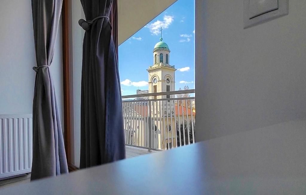 een raam met uitzicht op een gebouw met een klokkentoren bij Ani's Home newly built apartment in Boedapest