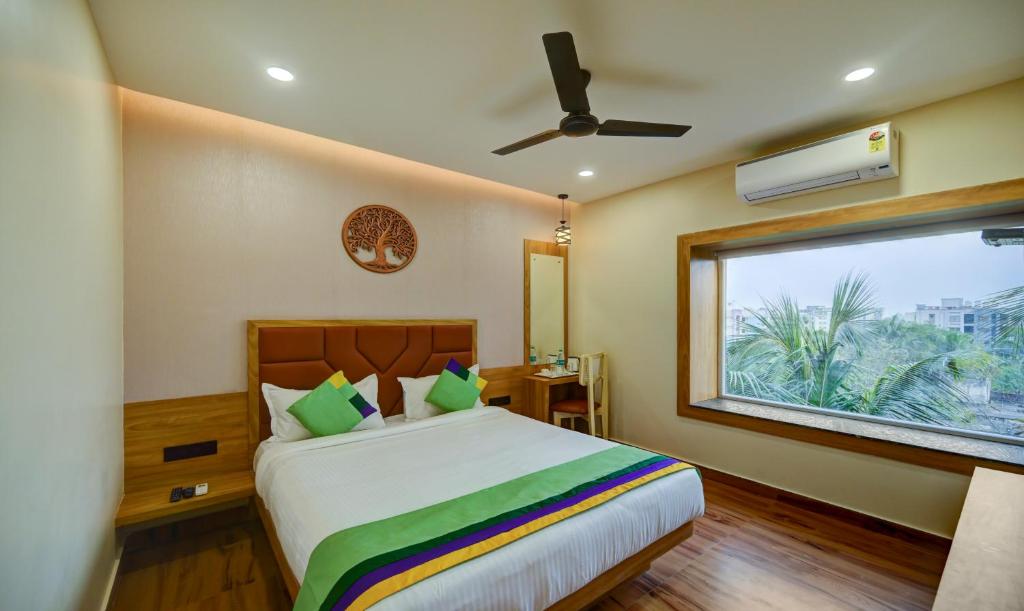 a bedroom with a large bed and a window at Treebo Trend Aasma Downtown in Bhubaneshwar