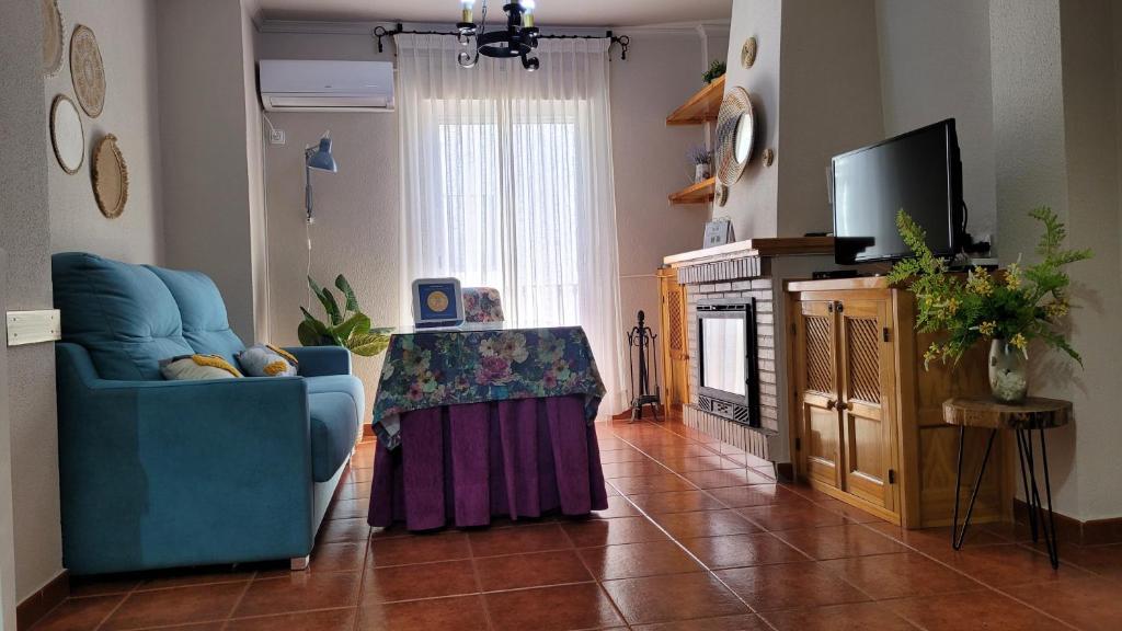 a living room with a blue chair and a television at Mi Casa En Benamahoma in Benamahoma
