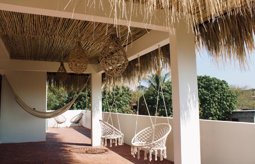 a patio with chairs and a hammock on a house at Casa Luni in Puerto Escondido