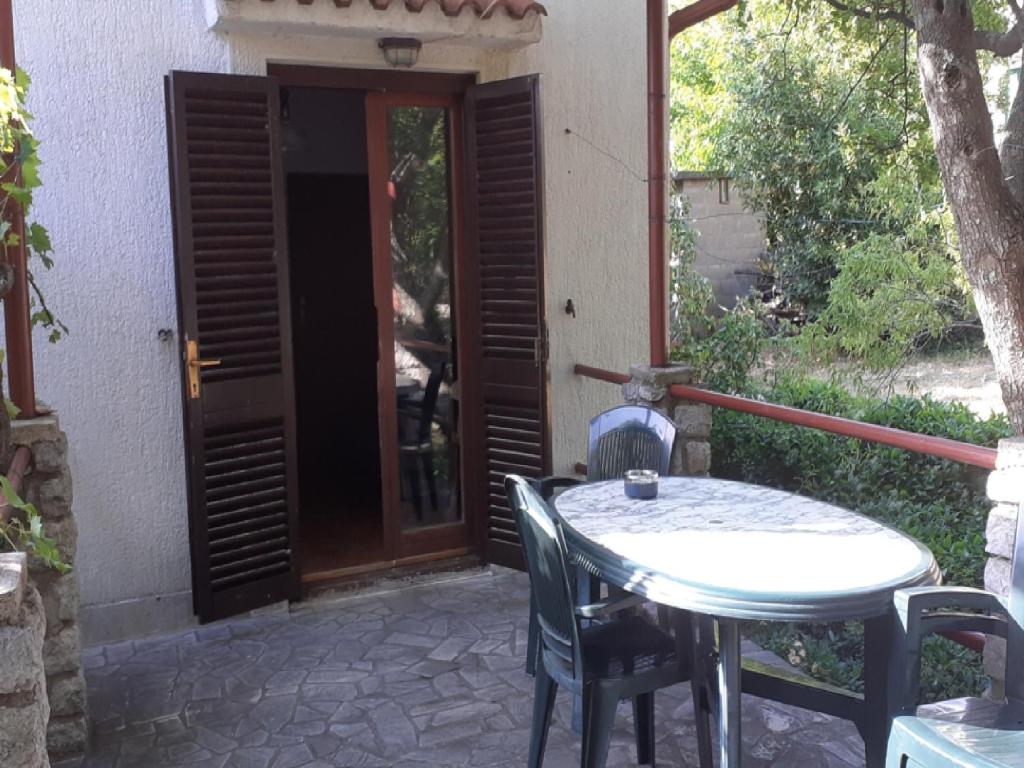 una mesa y sillas frente a una puerta en Apartments Rudi, en Klenovica