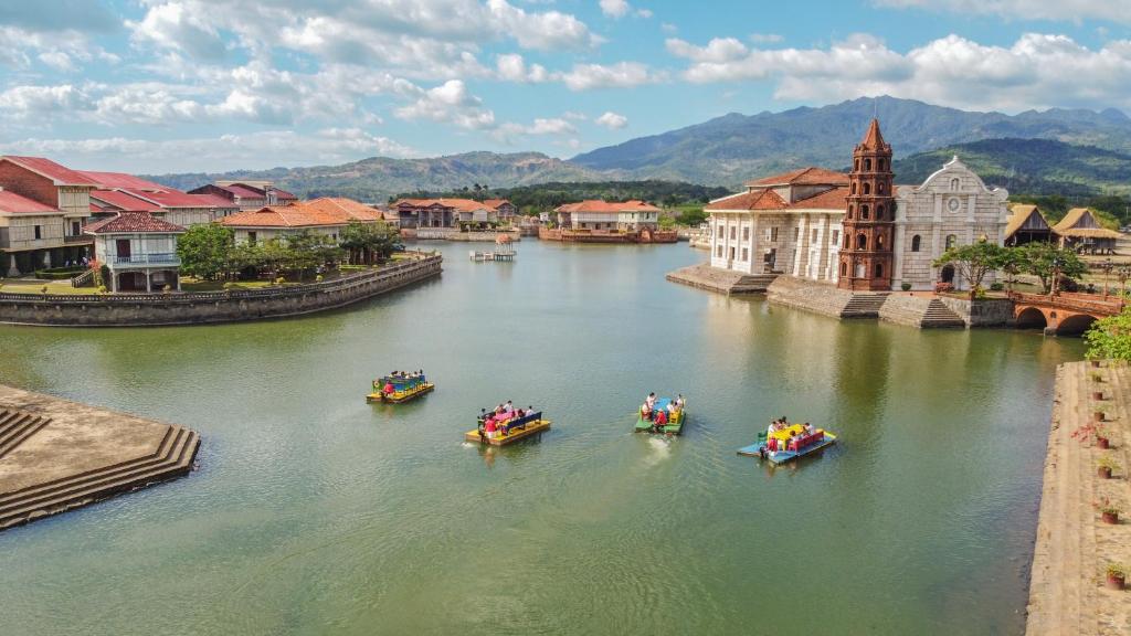 a group of people in boats on a river at Las Casas Filipinas de Acuzar in Bagac