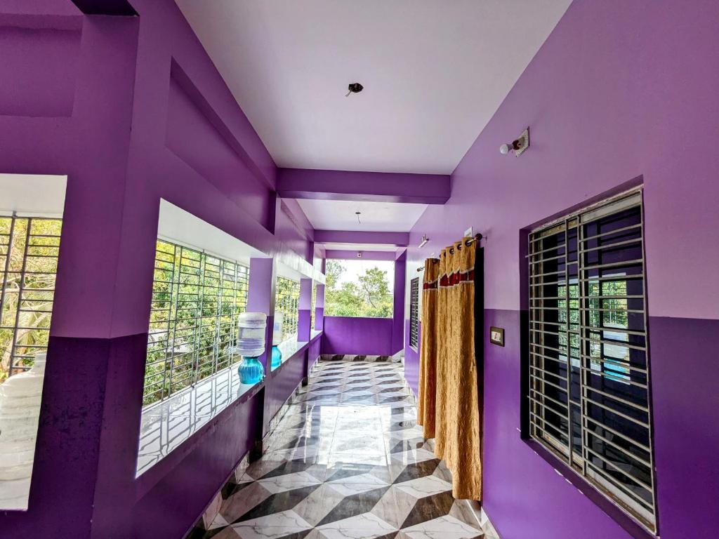 Purbbadulki的住宿－Sundarban Tulip Homestay, Pakhiralay, WB，一间拥有紫色墙壁的客房和一个带窗户的走廊