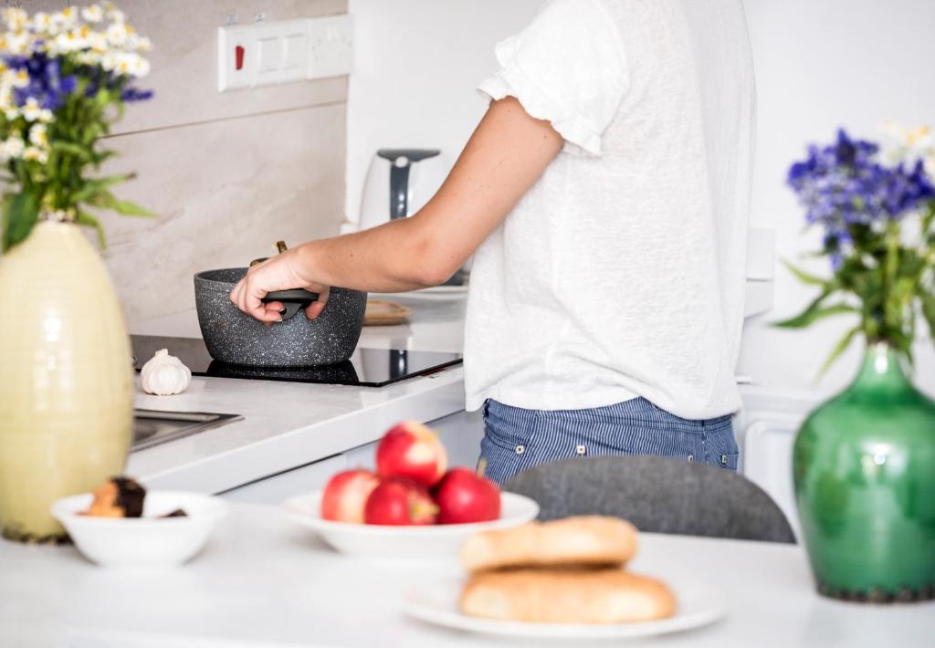 a person standing in a kitchen with apples and bread at River View Boutique Apts in Ayia Napa