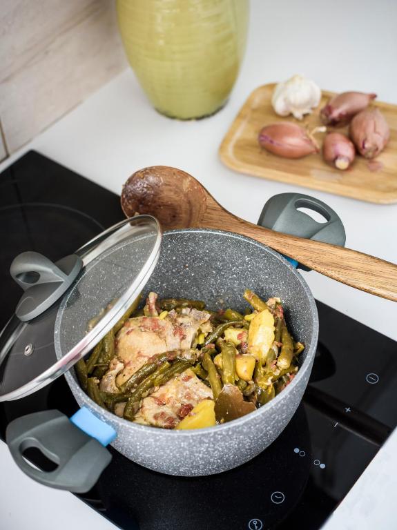 a pan filled with meat and vegetables on a stove at River View Boutique Apts in Ayia Napa