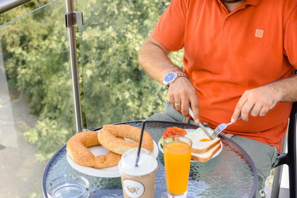 a man sitting at a table with a plate of food at River View Boutique Apts in Ayia Napa