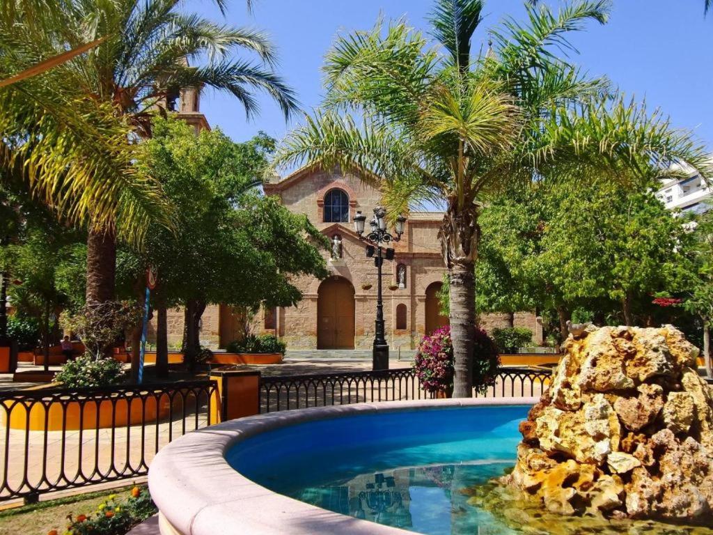 una piscina frente a una casa con palmeras en Apartamento cerca a la playa del Cura ! Cura Beach, en Torrevieja