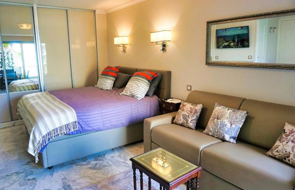 un salon avec un lit et un canapé dans l'établissement Studio Cannes center next to Croisette and rue d'Antibes, à Cannes