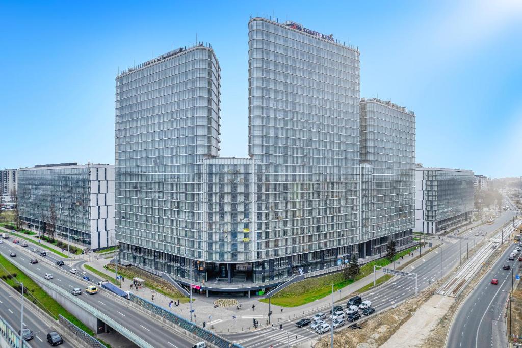 two tall buildings in a city with a highway at Vola Palace in Warsaw