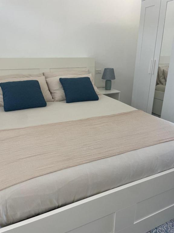 a bedroom with a large bed with blue pillows at Casa Grazia Apartments in Lipari