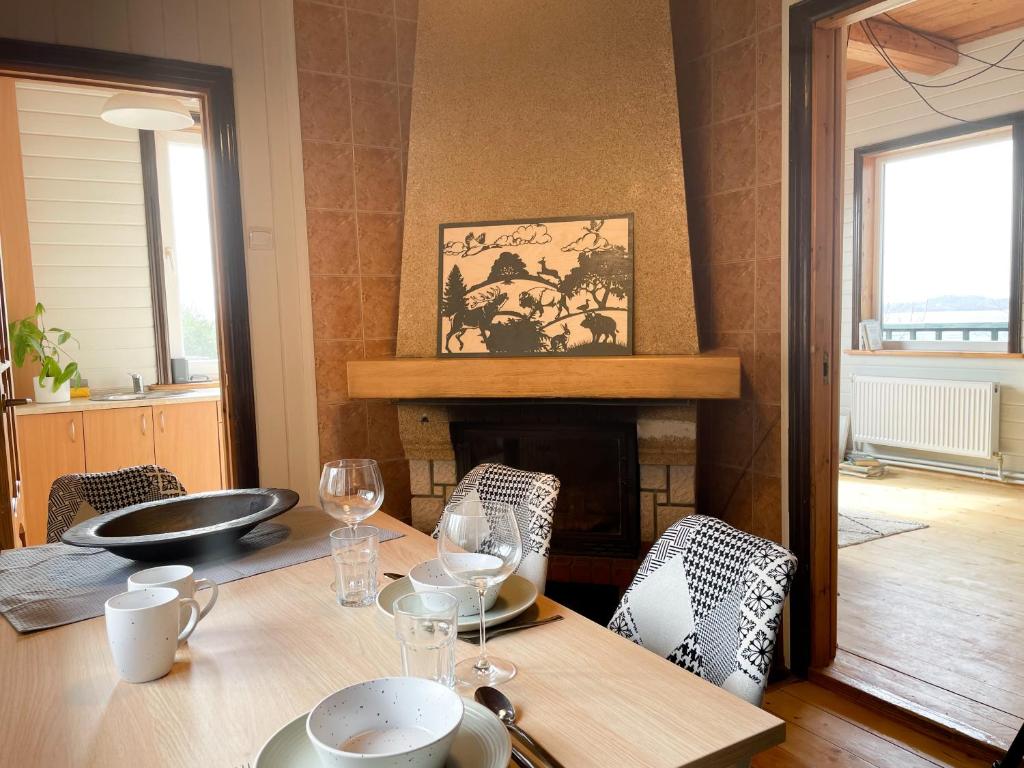 a dining room with a table and a fireplace at Rāznas Stāvkrasti in Kaunata