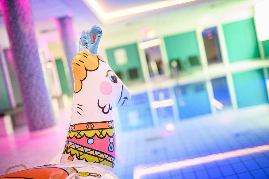 Um cão de brinquedo está a segurar um telemóvel à orelha. em Holiday Inn Lübeck, an IHG Hotel em Lübeck