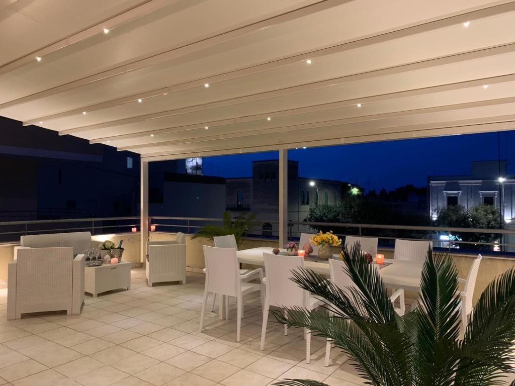 d'une terrasse avec des chaises blanches et une table offrant une vue. dans l'établissement Roomy Apartment with Terrace & Parking, à Lecce